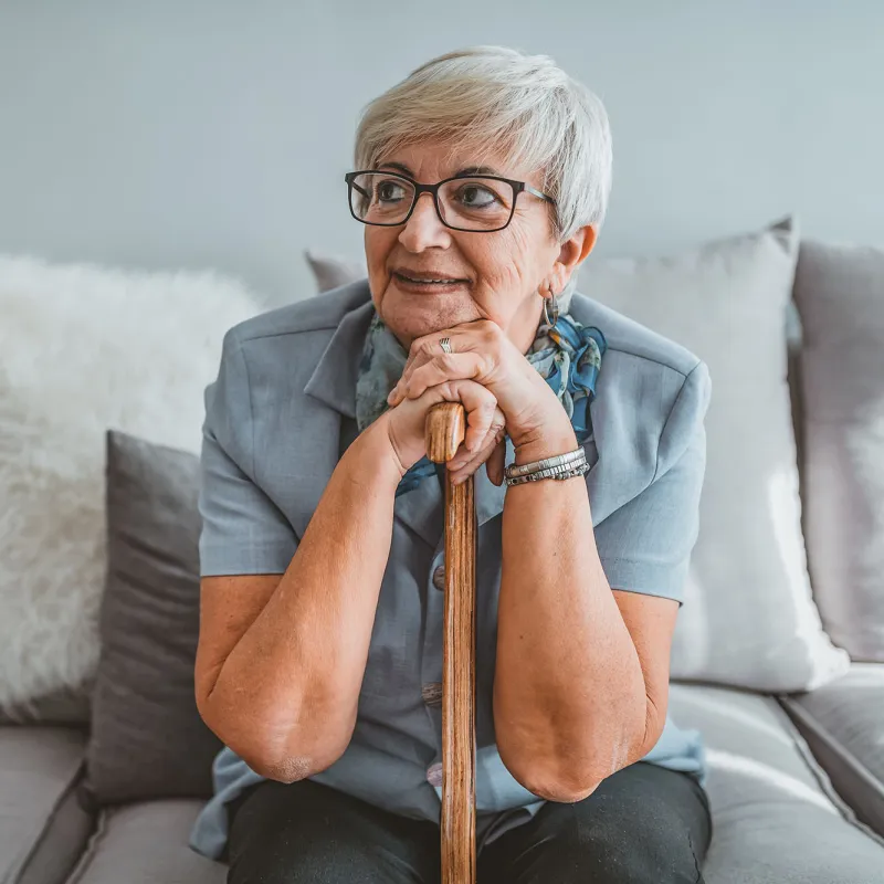 A woman sitting on her couch thinking. 