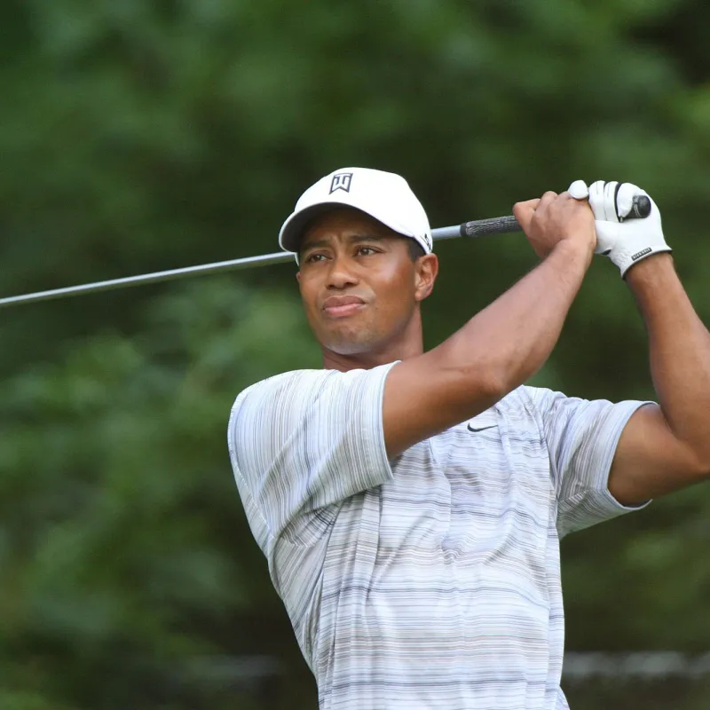 Golfer, Tiger Woods, watches his ball fly after swinging his golf club