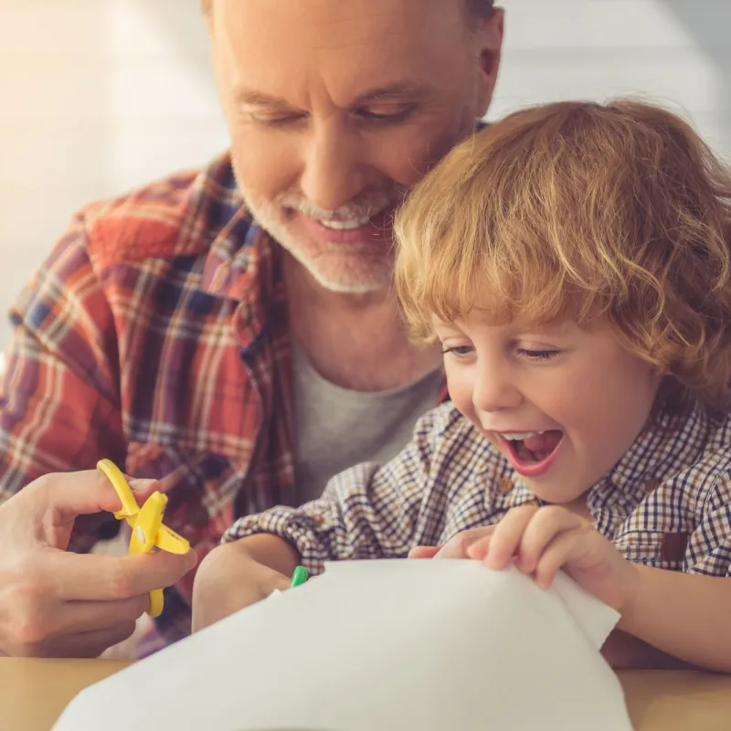 A father doing a craft project with his son.