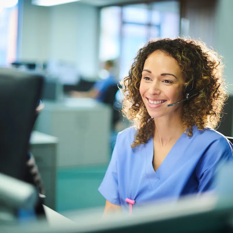 Woman in scrubs on phone headset