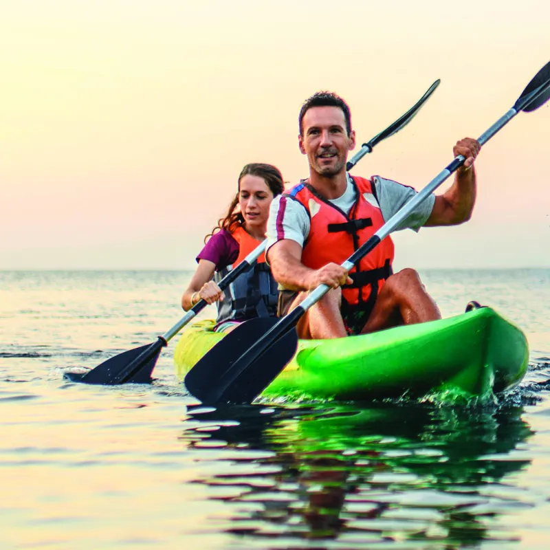 A couple kayaking on calm waters.