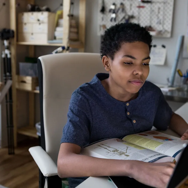 A young boy does his homework at the kitchen table