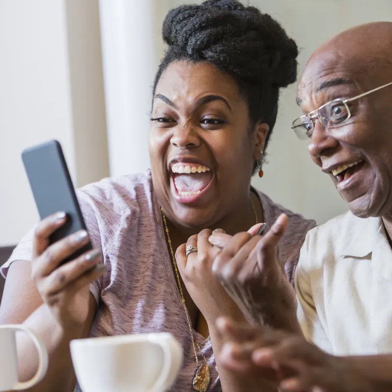 A couple laughing on a video call.