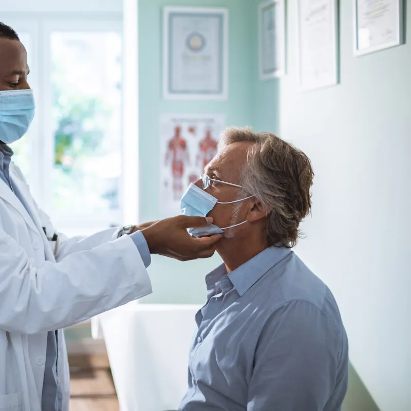 A male doctor examining a male patient. 