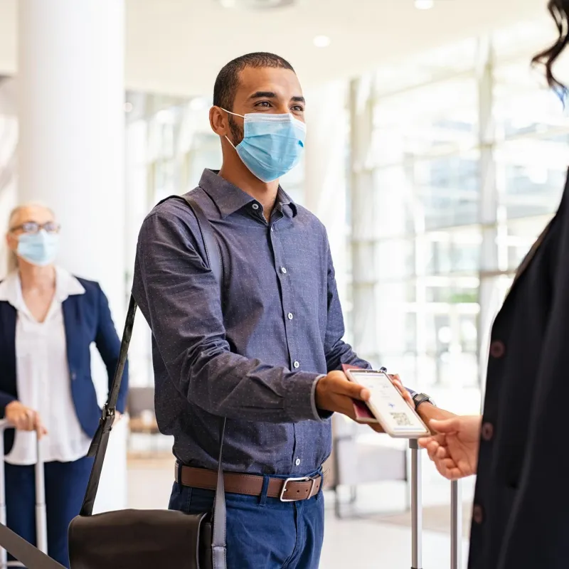 A gentleman showing an e-ticket to a flight teller