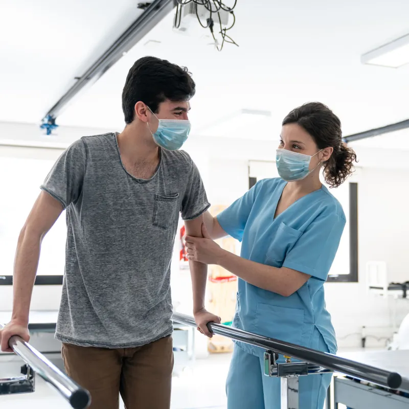 A man with a female nurse as they go through a session of physical rehab.