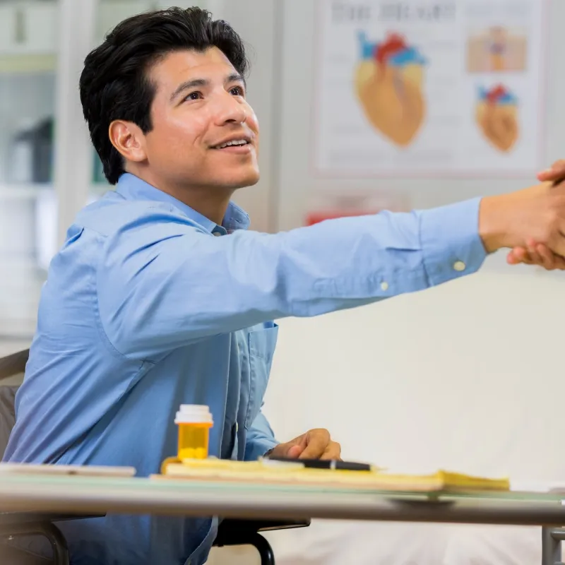 A man shakes the hand of a new doctor.