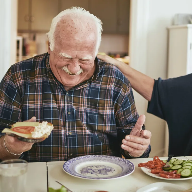 A couple enjoys a meal while laughing about their day.