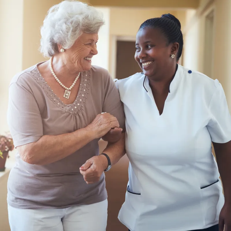 A woman walks with her nurse for treatment during an appointment.