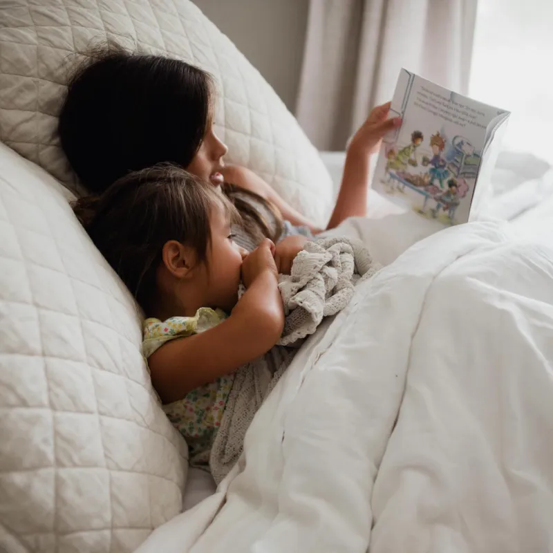 Older child reading to younger child