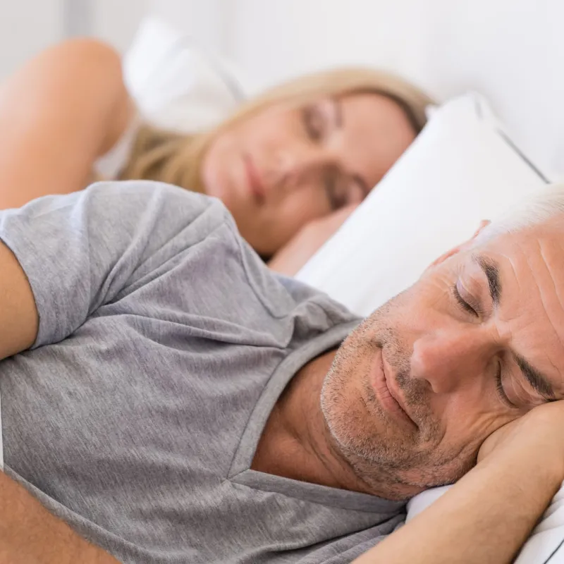 Mature couple sleeping on their bed