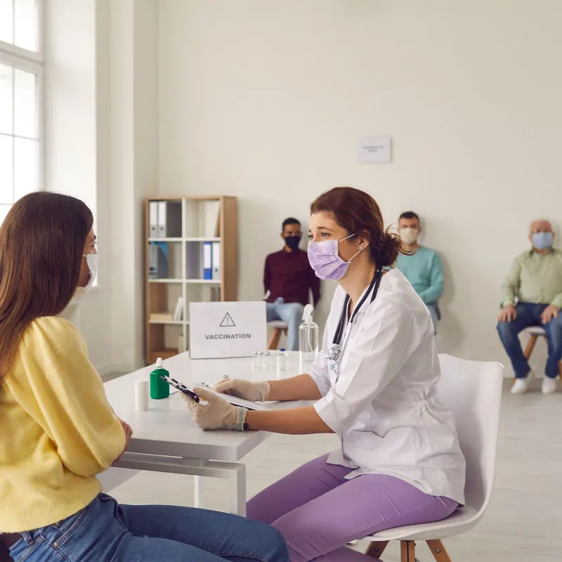 A nurse talking to a patient at a vaccine site