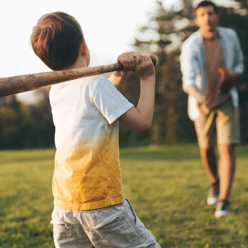 Father and son playing baseball outside