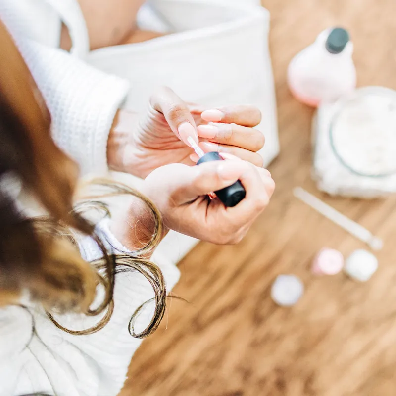 A woman takes some time for self care by painting her nails.