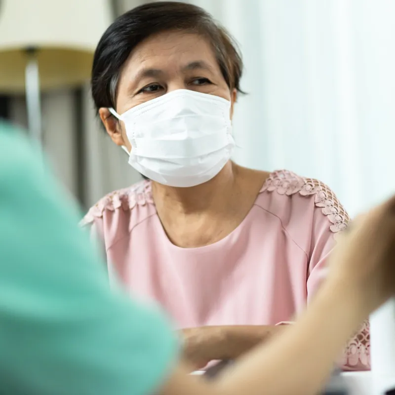 A woman at a doctor's appointment wearing a mask.