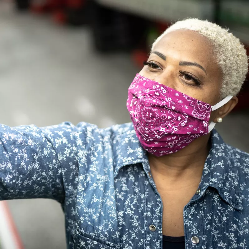 A woman wearing a cloth face mask at the grocery store.