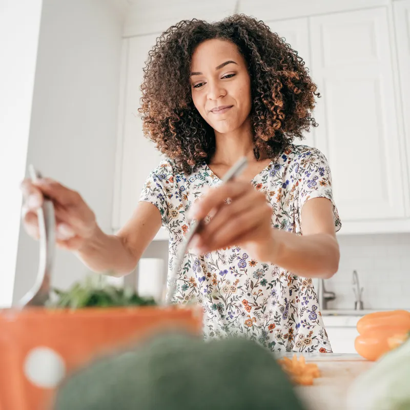 A woman making a salad at home.