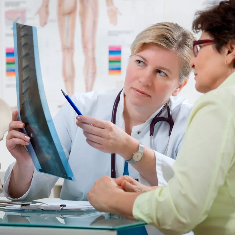 A woman looks at her back x-ray with her doctor