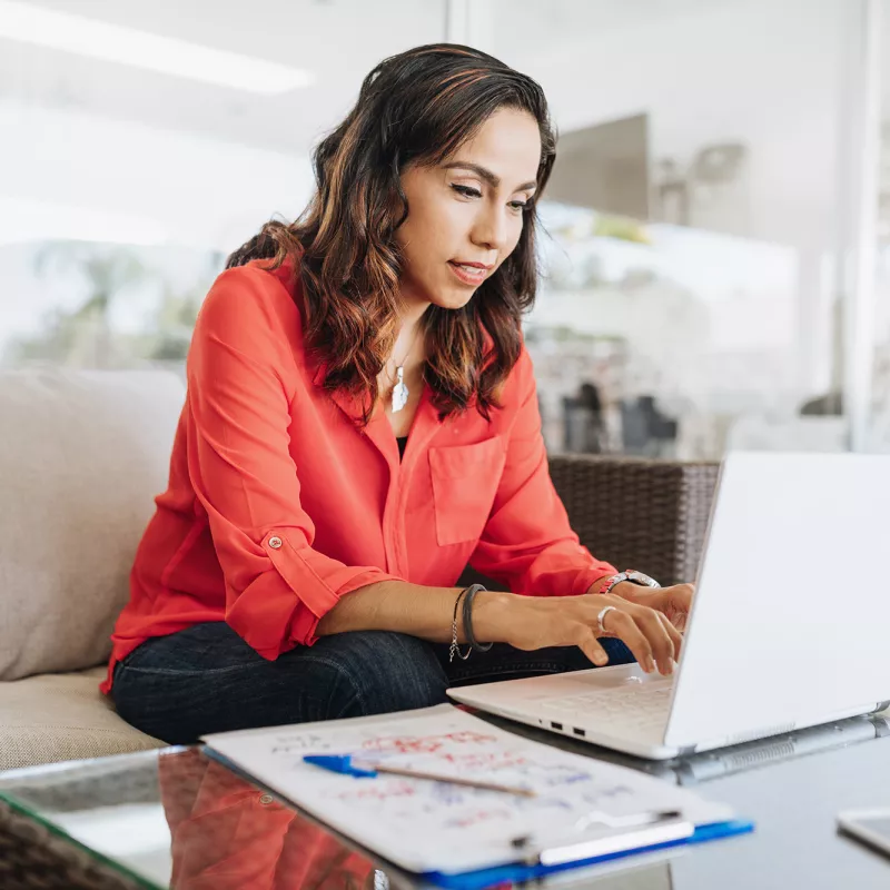 A woman on her laptop in her living room.