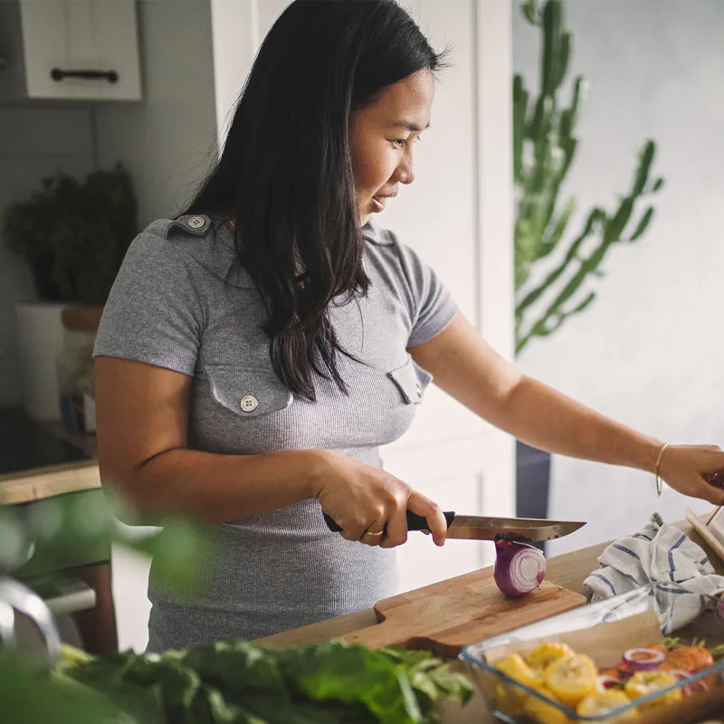 A young woman cooking at home.