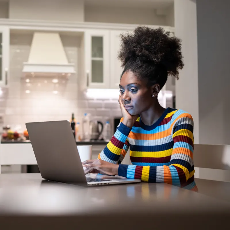 A woman in her living room and on her computer