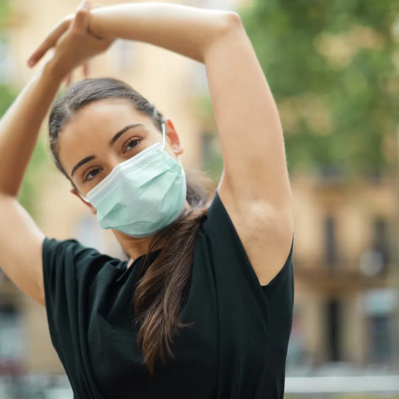 A woman stretching outside after a workout.