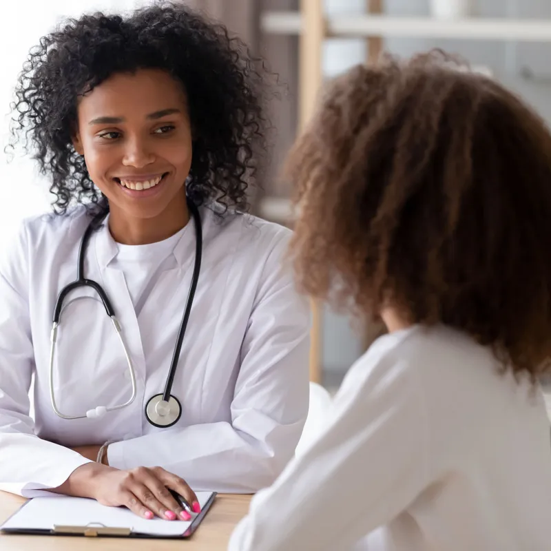 A black female doctor talks to an adult woman patient