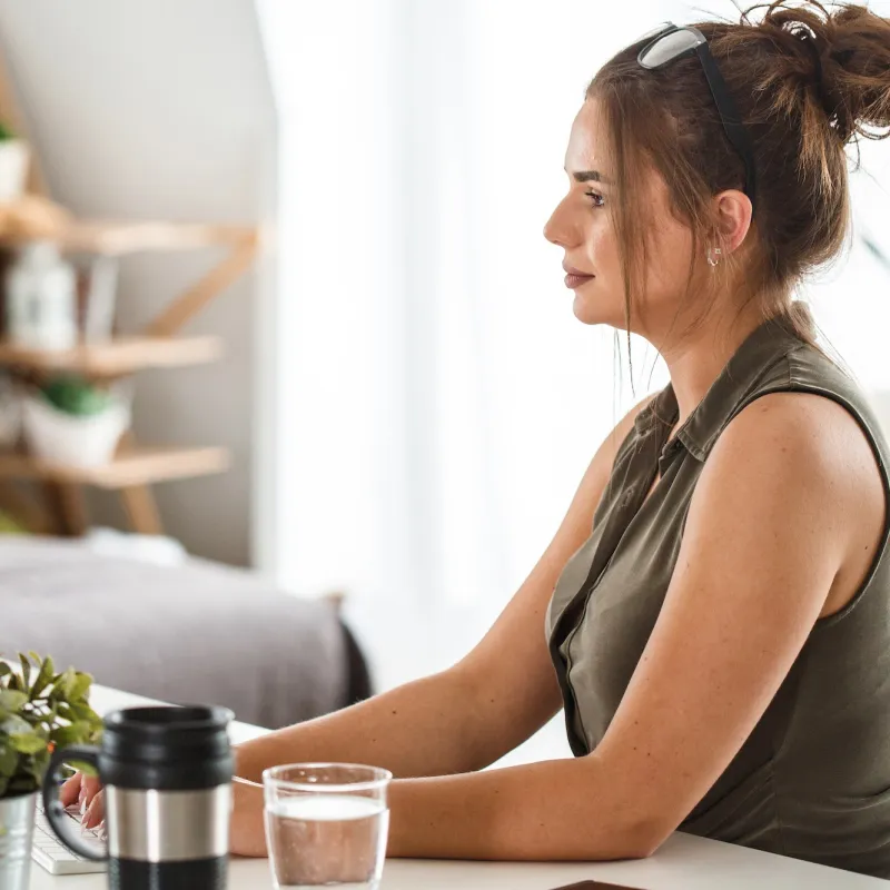 A woman sits with good posture while working at her desk.