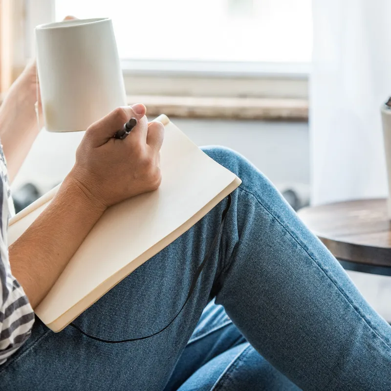 A woman indoors and journaling