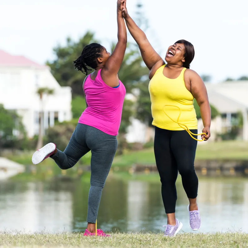 Two women high-five after a great workout outside.