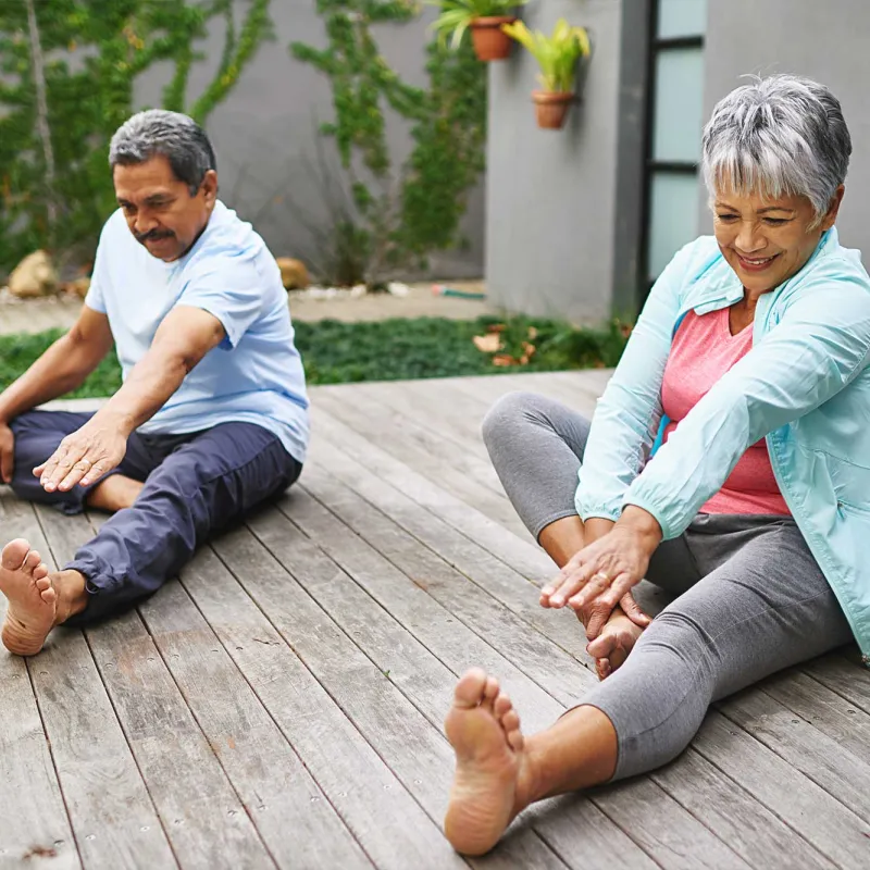 A couple doing leg stretches outdoors