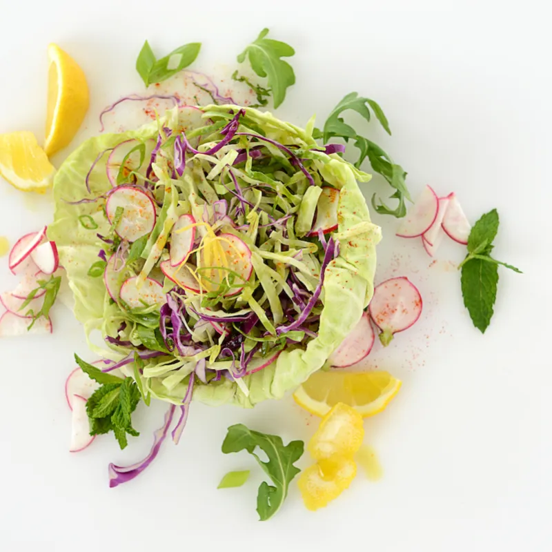 Mound of cabbage slaw with orange slice garnishes