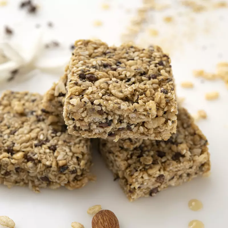 Stack of three crispy sesame treats on white surface