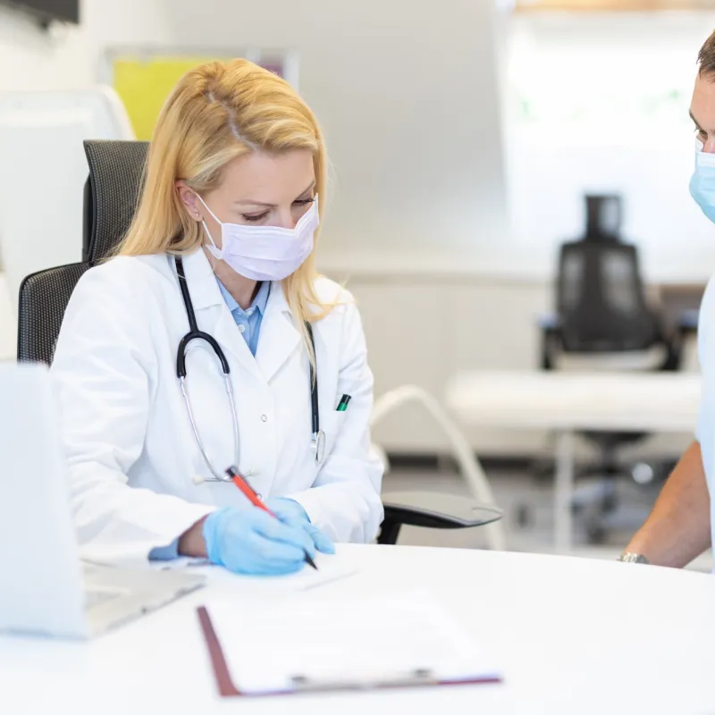 A man discussing his symptoms with his doctor.