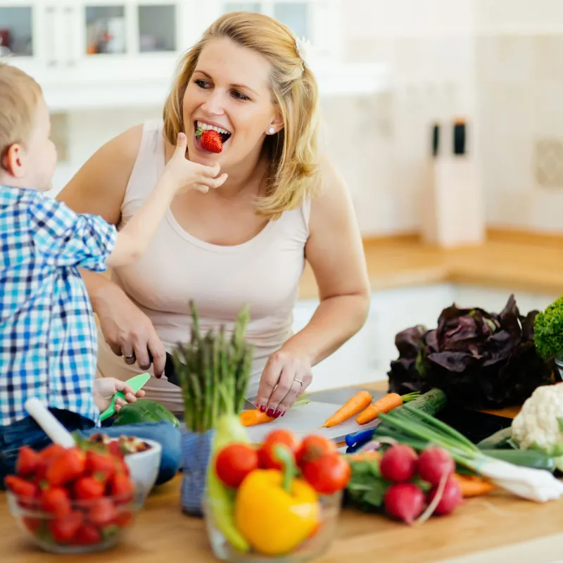 Mom eating strawberries with son.