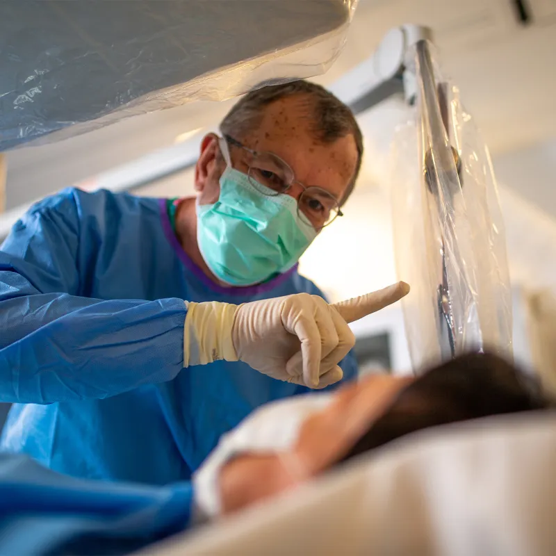 Neuro surgeon holding up a finger for a patient.