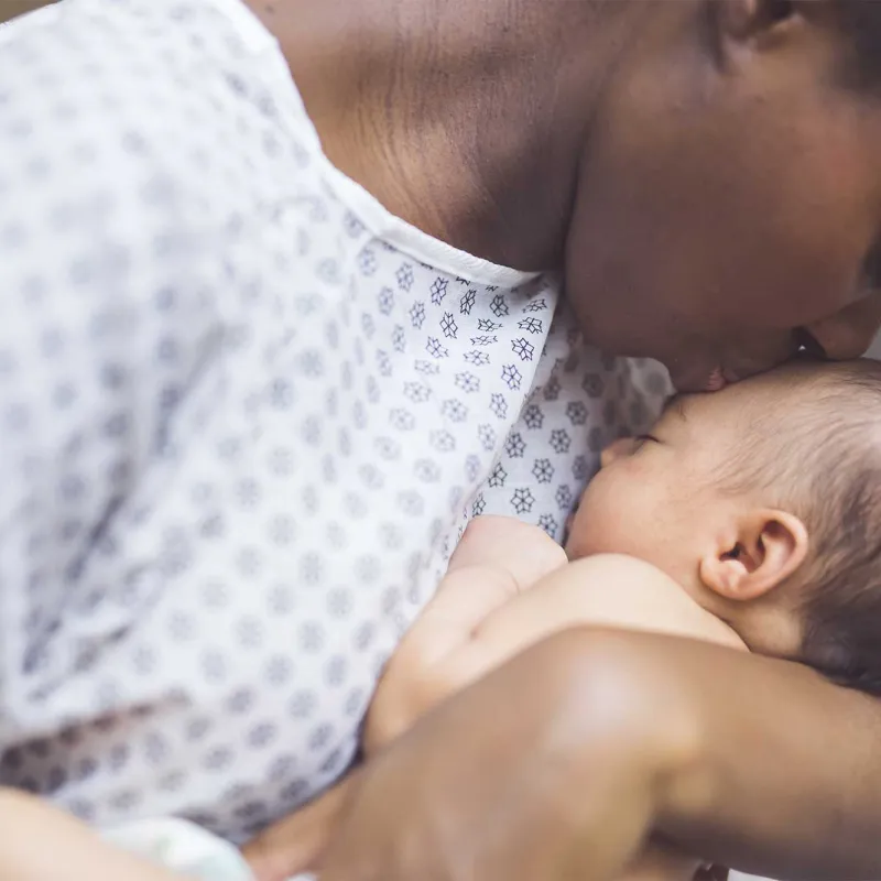 A mother kissing her newborn child