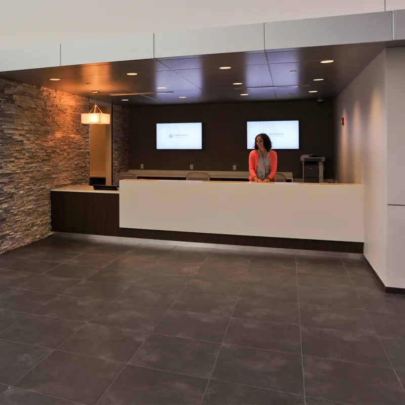 Front desk worker at the desk in the AdventHealth Nicholson Center at Celebration lobby.