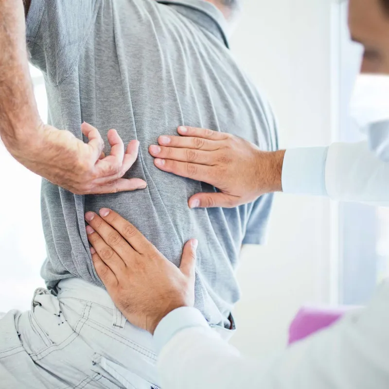 A man experiencing back pain at the doctor's office. 