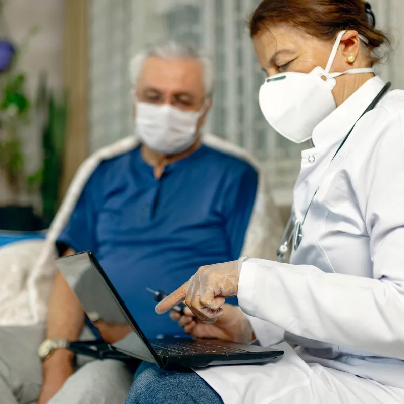 An older man being seen by a doctor. 