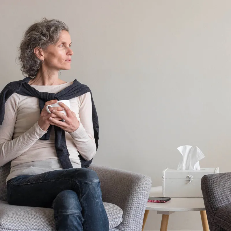 An older woman grieving at home. 