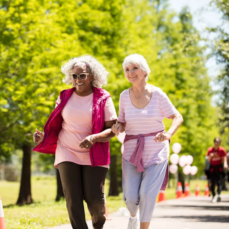 Two elderly women enjoying a walk in the park.