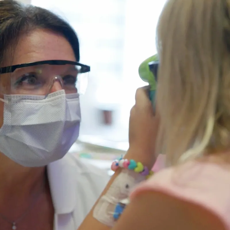 A Doctor Smiles as She Examines a Pediatric Patient