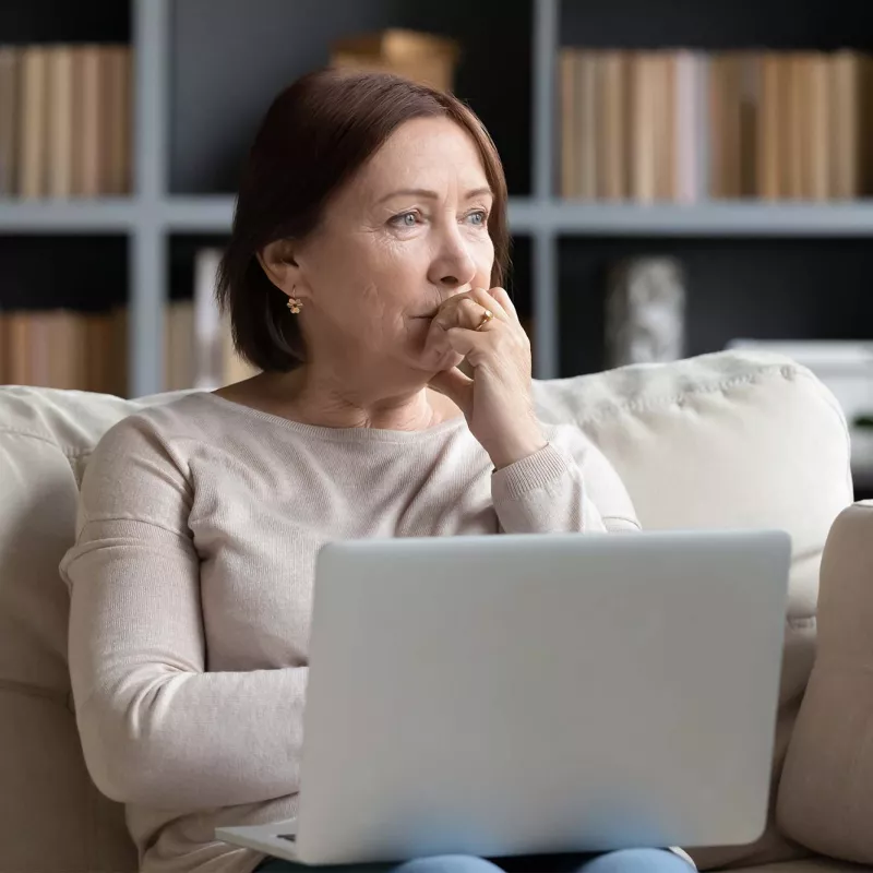 A woman thinking while on her laptop