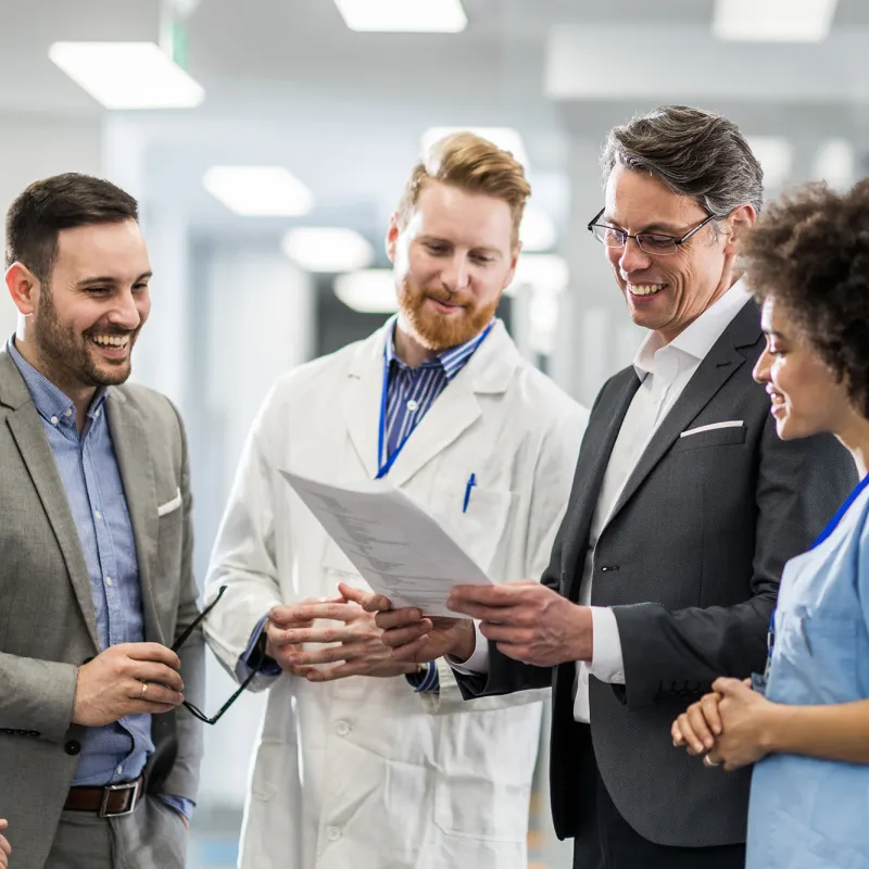 Physicians smiling and talking in hospital hallway