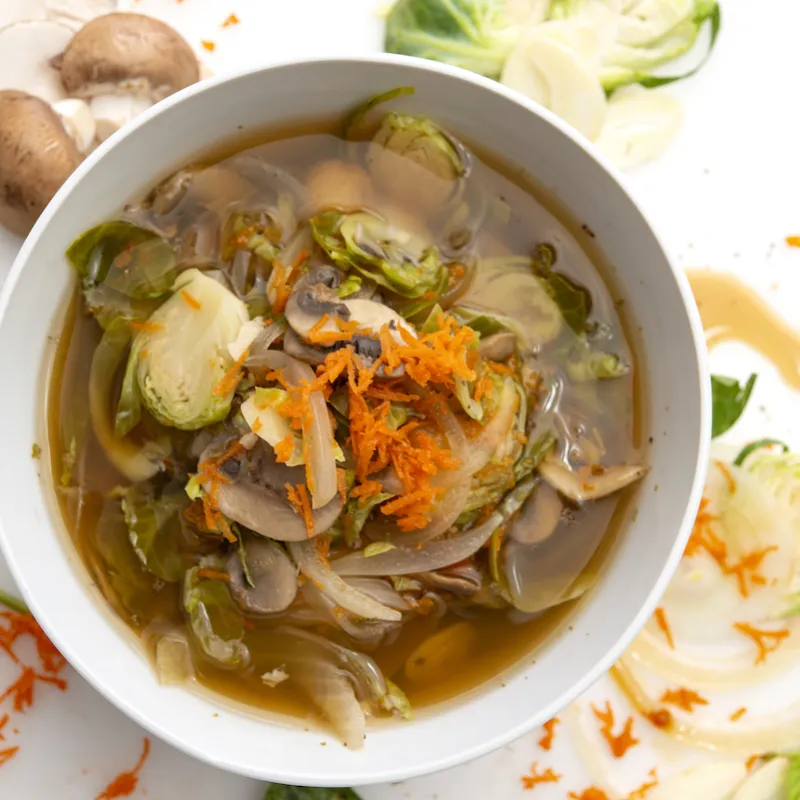 Bowl of Power Greens soup with mushroom and herb garnishes