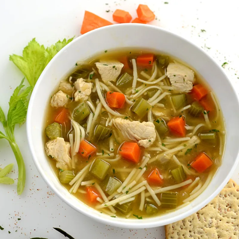 Bowl filled with a chicken noodle and vegetable soup