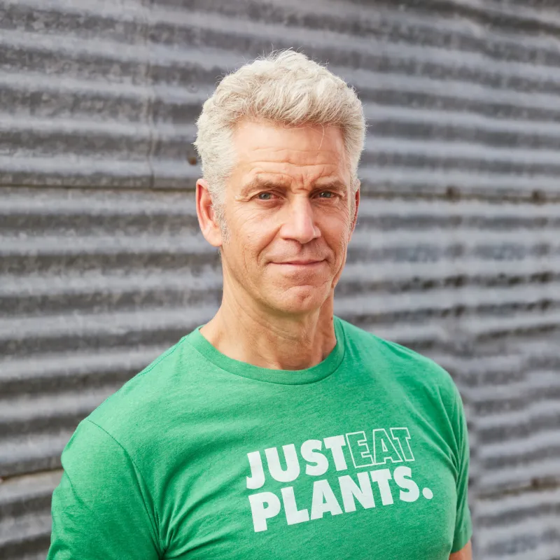 Photo of Rip Esselstyn wearing a green "Just Eat Plants" t-shirt