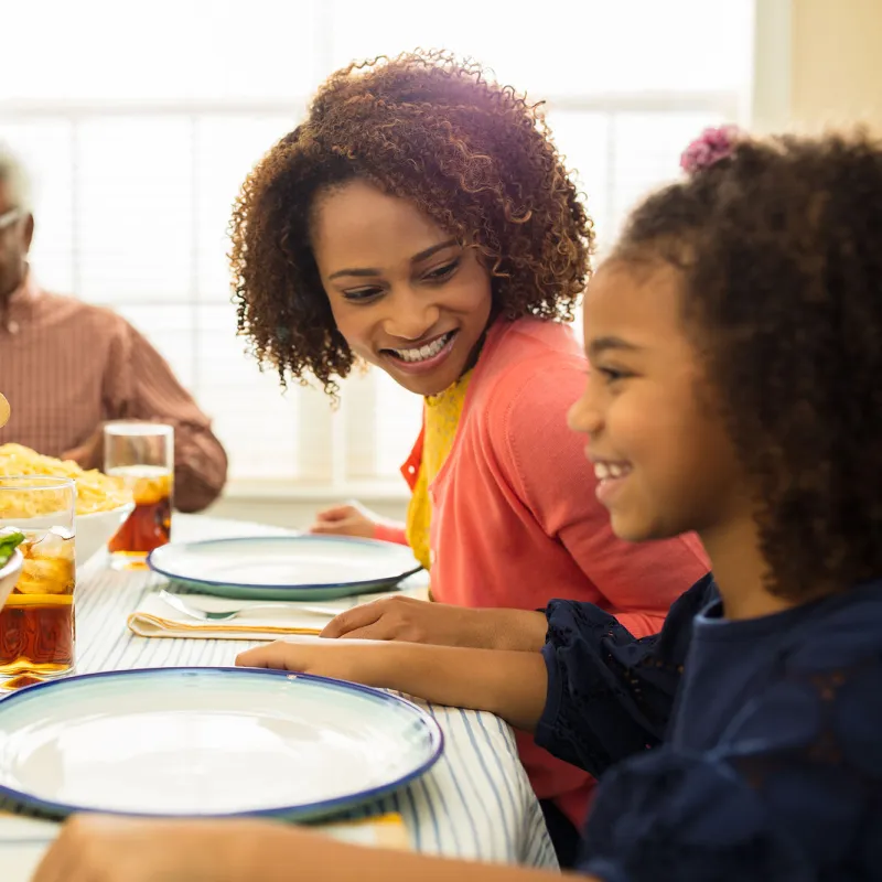 A family seating at the dinner table having a friendly conversation.