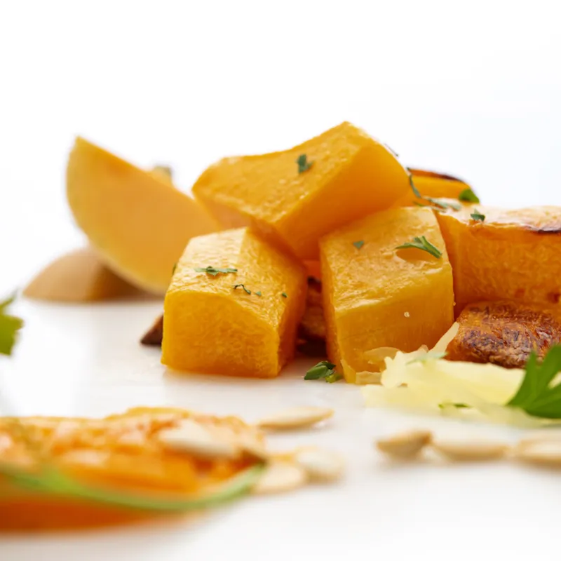 Seven chunks of butternut squash with parsley garnish